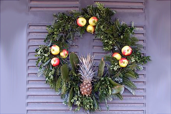 wreath on a door with apples and a pineapple