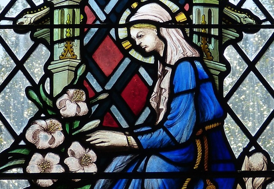 stained class depicting a woman tending to pink flowers