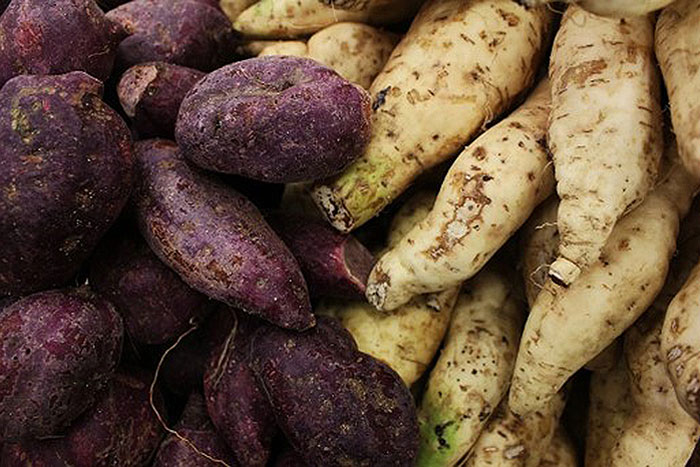 purple sweet potatoes next to tan sweet potatoes