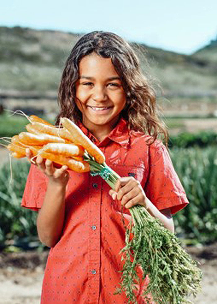 girl holding bunch of carrots