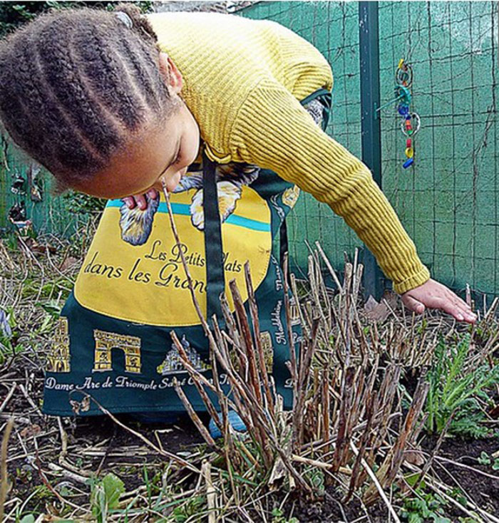 girl bent over touching dormant tall grass