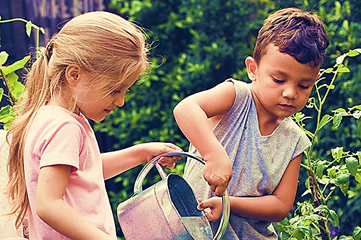 child with open arms in a garden