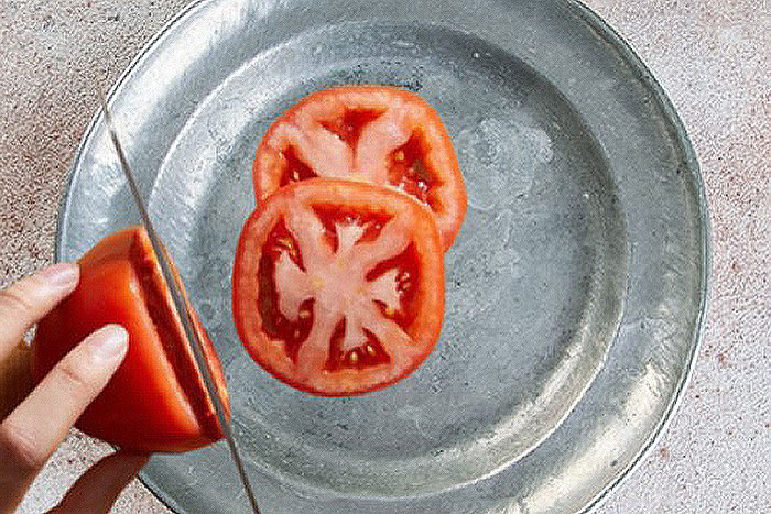 sliced tomato on a metal plate