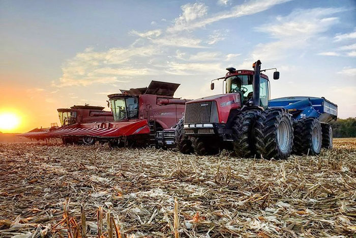 two tractors in a cut corn field