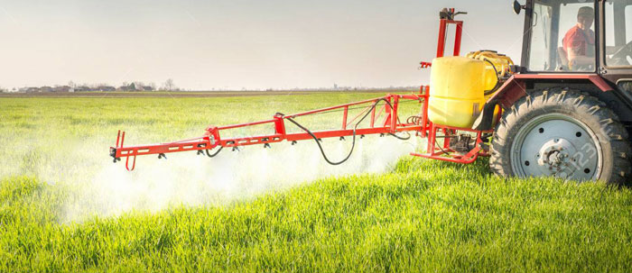tractor spraying crop field