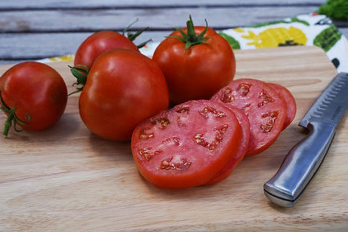 tomatoes on cutting board with knife