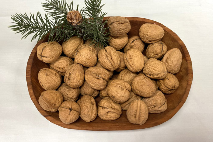 bowl of nuts with sprig of pine
