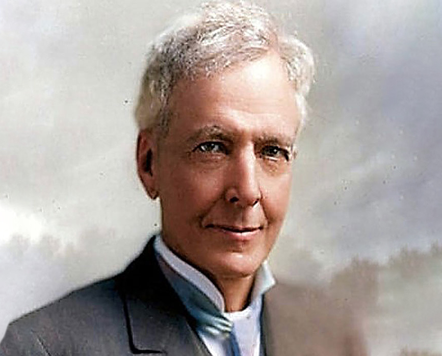 headshot of man with white hair and suit
